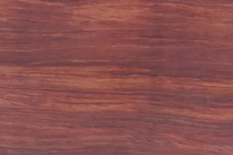 Textura rica y veteada de madera bubinga, con tonos rojizos y marrones que evocan la calidez de la naturaleza.