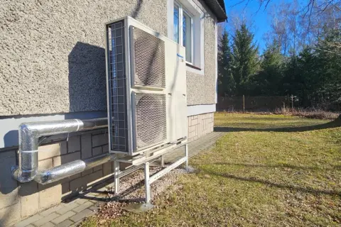 Pompa ciepła Panasonic zamontowana przy nowym domu. Instalacja zasilana dzięki dotacji, zapewnia ekologiczne ogrzewanie.