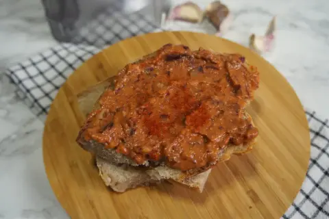 Pyszna pasta z czerwonej fasoli na chlebie, posypana papryką. Idealna na szybką przekąskę.