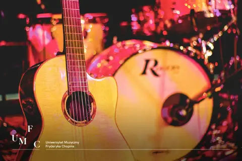 Gitara i bębny na scenie, gotowe do występu. Może to Łukasz Talarek przygotowuje się do koncertu?