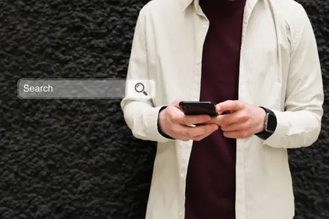 Mężczyzna z telefonem szuka w sieci informacji, jak włączyć Google Discover.