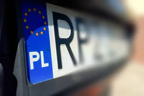Zbliżenie na polską tablicę rejestracyjną z symbolem UE. Czas na przerejestrowanie samochodu i nowe oznaczenia.