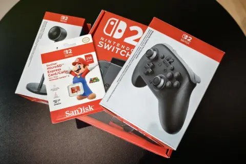 Pudełka z akcesoriami do Nintendo Switch: kontroler Pro, karta microSD 256 GB z Mario i kamera.