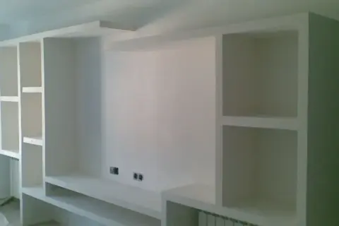 Parete attrezzata fai da te in cartongesso, con vani a giorno e mensole, pronta per accogliere TV e oggetti.