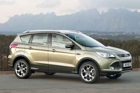 Złoty Ford Kuga 2 na tle górskiego krajobrazu.