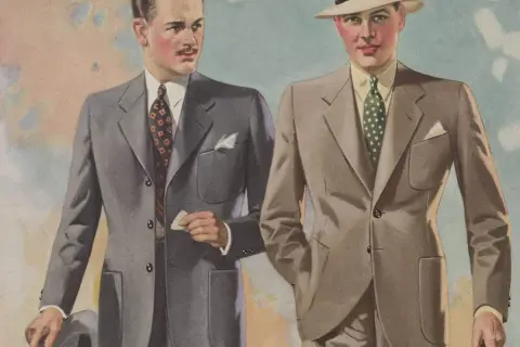 Två män i stilfulla kostymer, en grå och en beige, med hattar och slipsar. En tidlös mode 30 tal-stil.