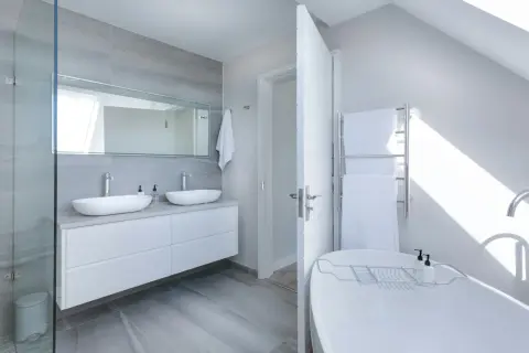 Salle de bain moderne avec double vasque, baignoire îlot et douche vitrée. Une belle idée rénovation salle de bain pour un espace lumineux et épuré.