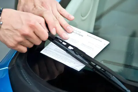 Man coloca una multa de estacionamiento bajo el limpiaparabrisas. ¡Qué carrera tan desafortunada!