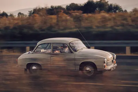 Klasyczny panner z lat 60. mija jesienny krajobraz.
