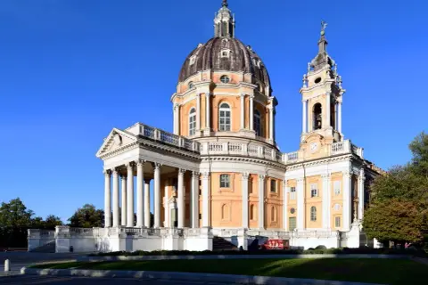 Basilica di Superga, maestosa con la sua cupola imponente, domina il panorama di Torino. Un gioiello architettonico sotto un cielo azzurro.