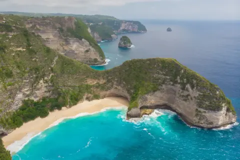 Spektakularne klify i turkusowa woda otaczają ukrytą plażę, jedno z najpiękniejszych miejsc na **plaze bali**.