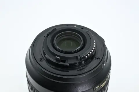 Zbliżenie na mocowanie obiektywu Nikon 18-105mm z widocznymi stykami i elementami optycznymi.