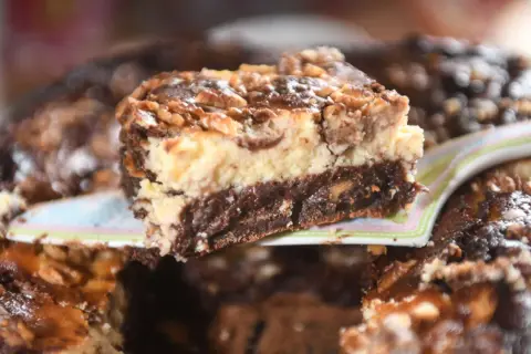 Ein Stück Schoko-Käsekuchen mit Walnüssen, der so gut aussieht, dass man ihn sofort probieren möchte – ein echter "friss dich dumm kuchen"!