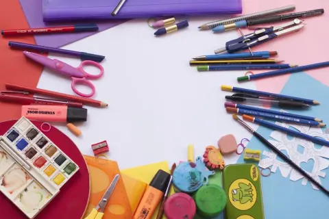 Bunt und ordentlich: Buntstifte, Scheren, Wasserfarben und mehr liegen bereit, um Schulsachen zu organisieren.