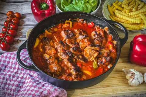 Herzhaftes Schaschlik-Rezept in Gusseisenpfanne mit Paprika, Zwiebeln und Tomaten. Dazu Pommes und frische Kräuter.