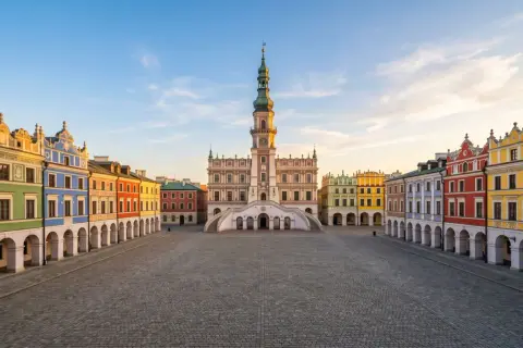 Rynek w Zamościu z kolorowymi kamienicami i ratuszem.