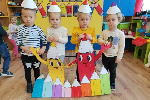 Dzieci w czapkach urodzinowych świętują dzień kredki. Pomysły na kreatywne zabawy z kolorowymi kredkami.