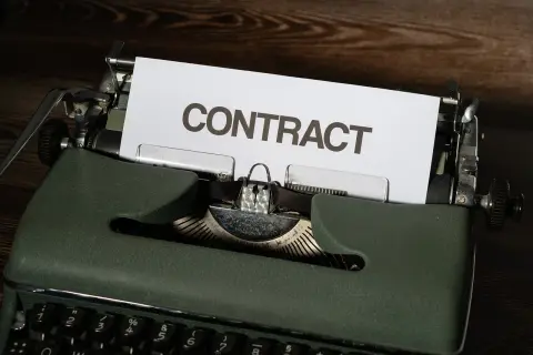 Stara maszyna do pisania z kartką z napisem "CONTRACT". Czas na wypowiedzenie umowy B2B.