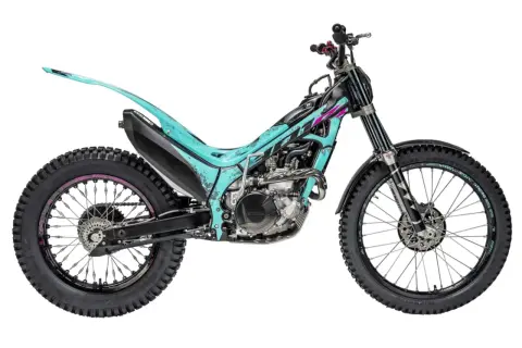 Una moto de trial color turquesa y negro, lista para superar cualquier obstáculo.