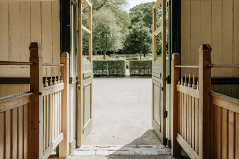 Öppna dörrar leder ut till en trädgård med en vacker grind och ett staket.