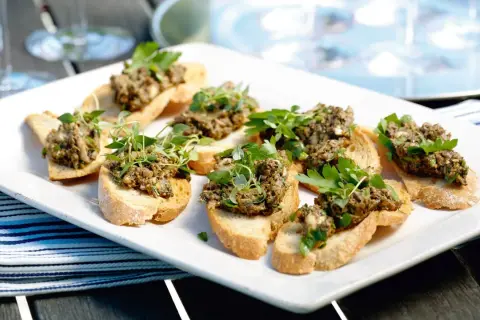 Små crostini med en härlig tapenade, toppade med färska örter. Perfekt som tilltugg!