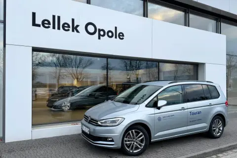 Srebrny Volkswagen Touran przed salonem Lellek Opole.