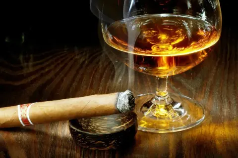 Dymiące cygaro i kieliszek bursztynowego trunku. Czy whisky podnosi cukier? To pytanie zadaje sobie wielu, delektując się tym zestawieniem.