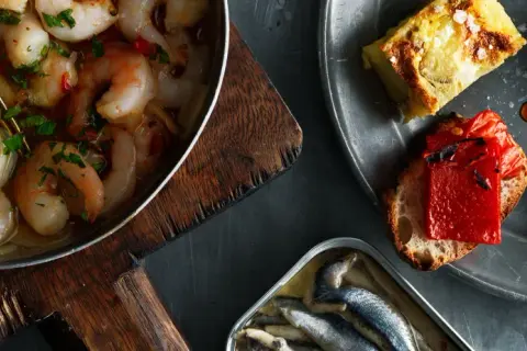 En härlig samling tapas med räkor i vitlök, sardiner och bröd med ost och paprika. Perfekt vin till tapas.