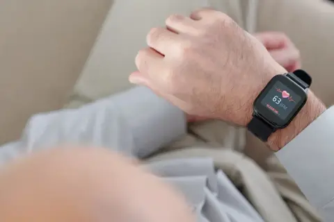 Mężczyzna sprawdza na smartwatchu swój niski puls, który wynosi 63 uderzenia na minutę.