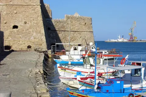 Port w Rethymno, Kreta. Listopad. Słoneczna, choć chłodna pogoda sprzyja spacerom po nabrzeżu wśród kolorowych łodzi rybackich i potężnej twierdzy.
