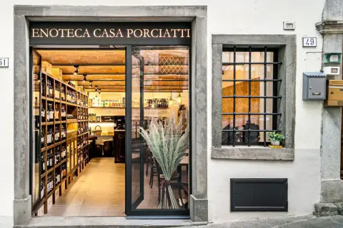 Enoteca Casa Porciatti, sklep z winami w sercu Chianti, zaprasza do degustacji. Wnętrze pełne butelek i ceglanych ścian.