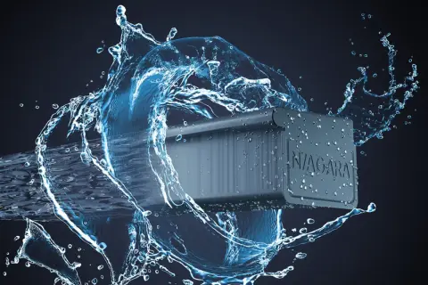 Dynamiczny strumień wody otacza fragment nowoczesnych systemów rynnowych Niagara, podkreślając ich odporność i skuteczność w odprowadzaniu deszczu.