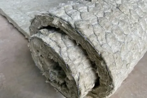 Gerolltes Dämmmaterial mit Drahtgeflecht. Um asbest erkennen zu können, ist Vorsicht geboten, da es sich um ein gesundheitsschädliches Material handelt.
