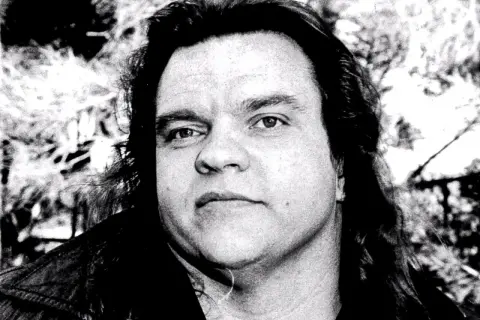 Porträt von Meat Loaf, dessen Todesursache nach wie vor diskutiert wird. Sein Blick ist intensiv, die Haare lang und zerzaust.
