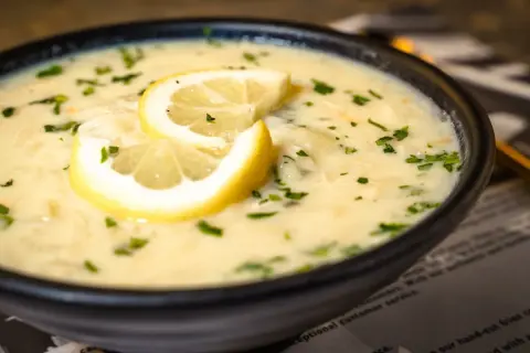 Aksamitna zupa cytrynowa, ozdobiona plasterkami cytryny i posypana natką pietruszki, kusi swoim aromatem.