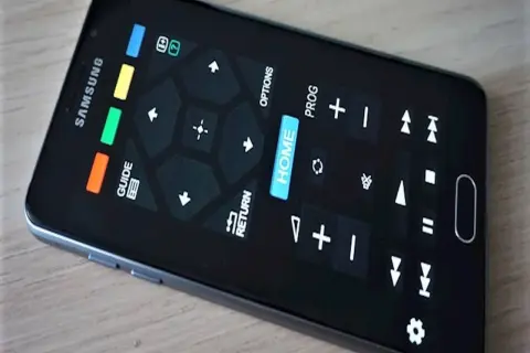 Smartfon z ekranem imitującym aplikację pilot do telewizora. Widoczne przyciski nawigacyjne, "HOME", "GUIDE", "RETURN" i inne funkcje.