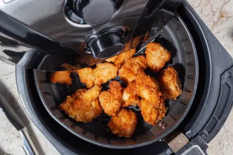 Chrupiące kawałki kurczaka w frytkownicy beztłuszczowej. Czy air fryer jest rakotwórczy? Bezpieczne gotowanie to podstawa.