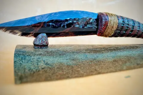 Ein kunstvoll gefertigtes Messer mit einer Klinge aus Obsidian, die wie ein Bergsee reflektiert. Die Griffverwendung von Obsidian zeigt seine vielseitige Schönheit.