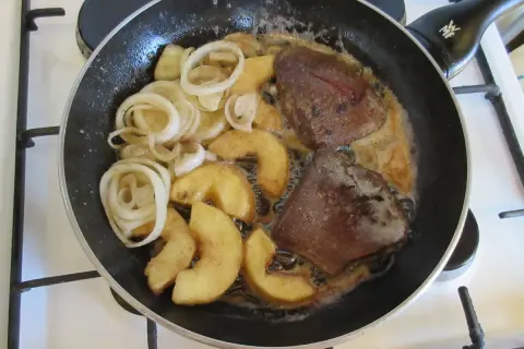 Leber braten: Zwiebelringe und Apfelspalten in der Pfanne mit der Leber garen.