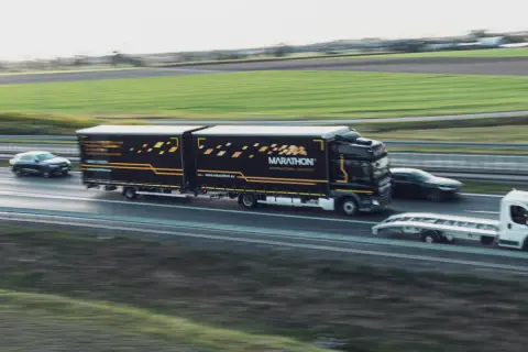 Ciężarówka Marathon International Logistics z naczepą jedzie autostradą. To część pakietu mobilności, który zapewnia sprawny transport.