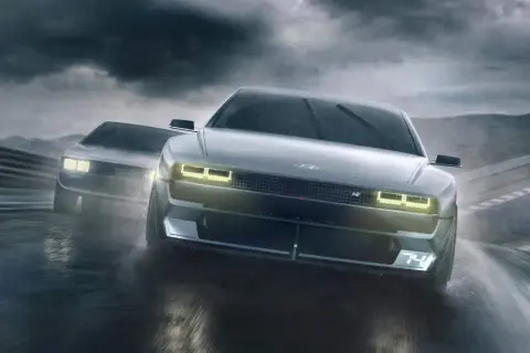 Dwa Hyundai N Vision 74 pędzą po mokrym torze wyścigowym w deszczu.