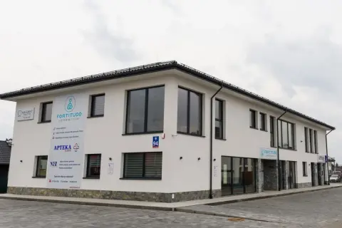 Nowoczesny budynek centrum medycznego Fortitudo z szyldami placówek.