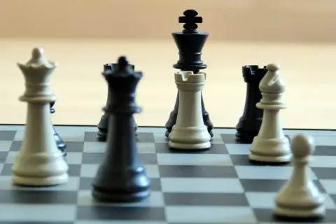 Szach królowi! Czy można zrobić roszadę po szachu? Na szachownicy białe i czarne figury, w tym król, hetman i wieża, czekają na ruch.