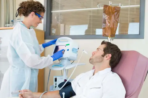 Eine Krankenschwester überwacht die Vitalwerte eines Patienten während einer Chemotherapie. Die Frage, welche Chemo am schlimmsten ist, beschäftigt viele.