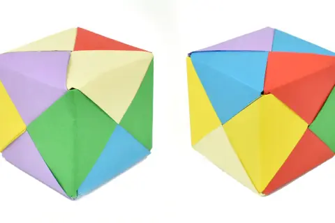 Dos cubos de papel para imprimir, hechos de módulos de colores: verde, amarillo, lila, azul, rojo y crema.