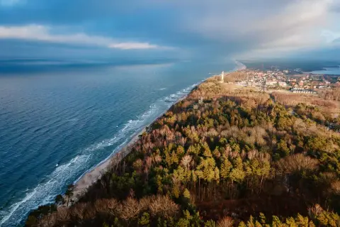 Widok na wybrzeże Bałtyku z latarnią morską i lasem. Wspaniałe niechorze atrakcje czekają na odkrycie!