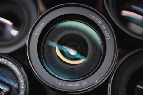 Zbliżenie na kilka obiektywów aparatów fotograficznych, w tym Canon EF.