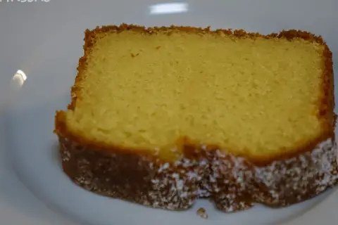 Ein saftiges Stück Kuchen mit Dinkelmehl und Quark, leicht mit Puderzucker bestäubt.