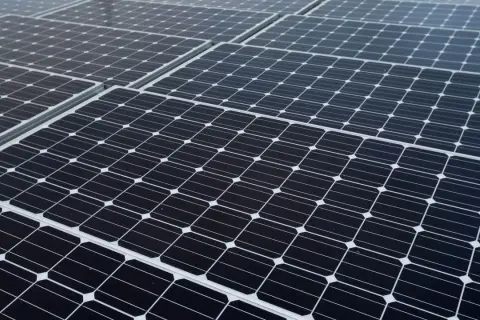 Panele fotowoltaiczne, czyli oze co to, tworzą gęsty wzór. Każdy panel składa się z wielu mniejszych ogniw.