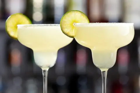 Två frostiga margaritas med saltkant och lime. Perfekt för en varm sommardag.
